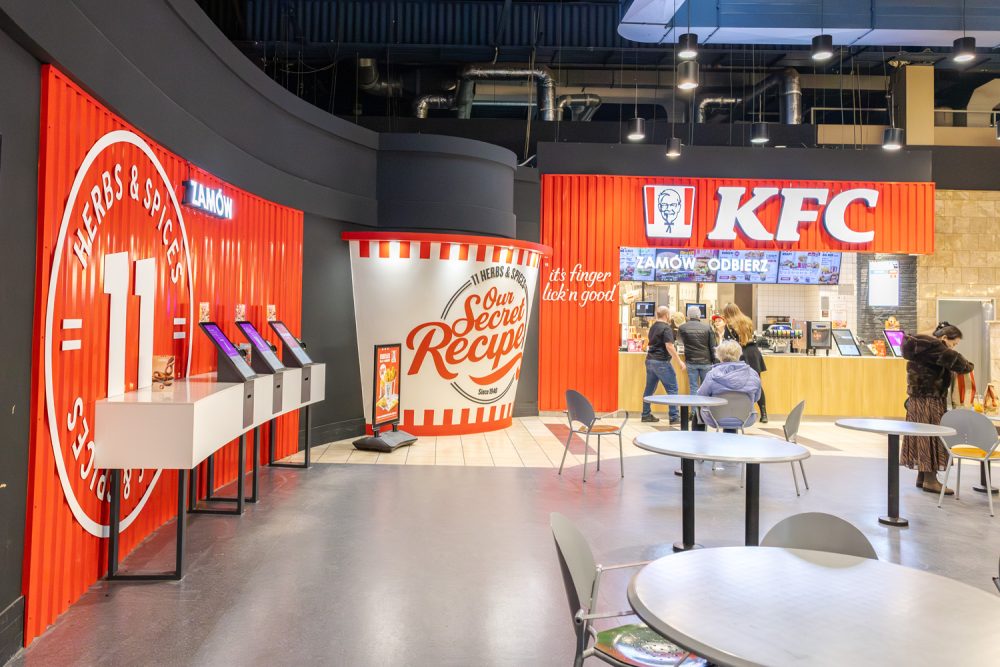 Stoliki i ekrany do składania zamówień w restauracji KFC w M1 Marki